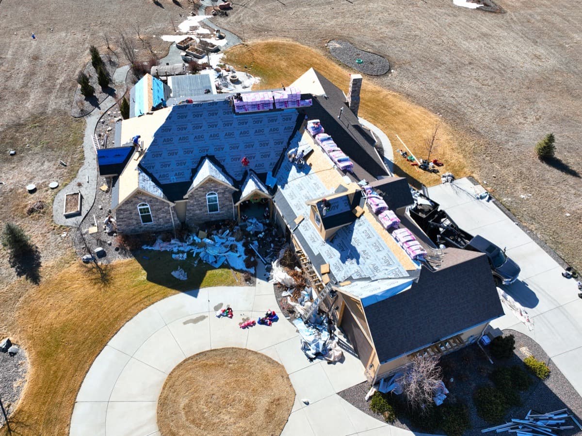 Stone and brick estate home mid roof replacement with crew and materials