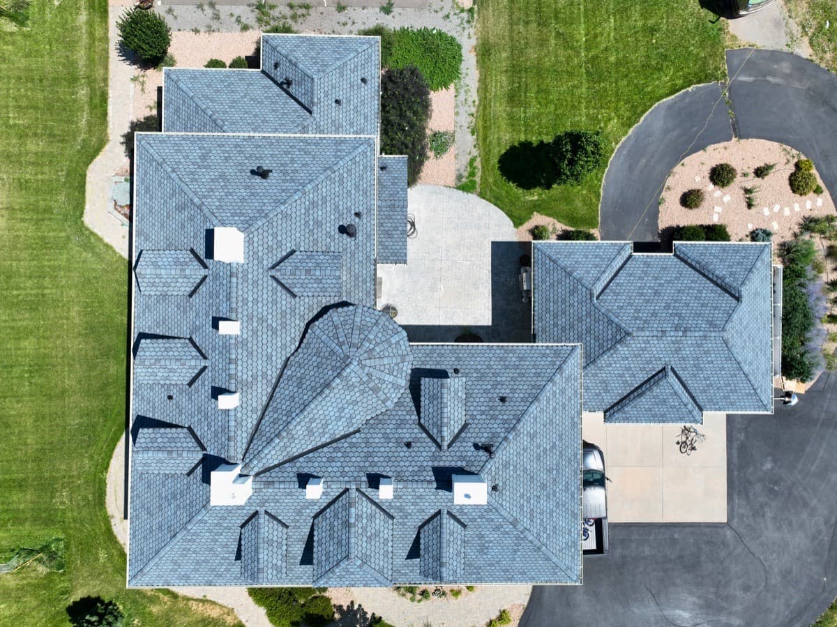 Completed designer shingle roof on large home with aerial top down view