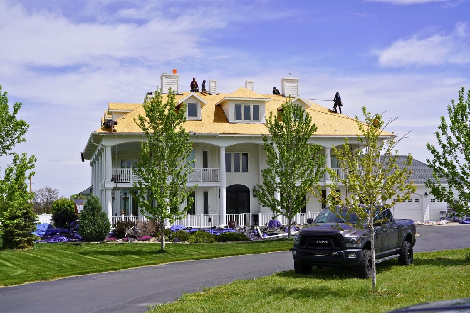 Gates Enterprises crew performing a full tear off roof replacement on a large home